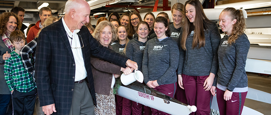 SPU donors Daryl and Claudia Vander Pol christen a racing shell gifted to the women's rowing team.