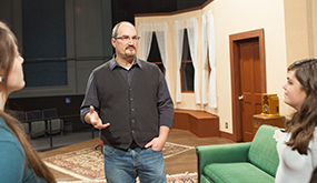 Theatre professor Richard Lorig talks with students on the set in McKinley Hall theatre.
