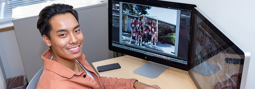 An SPU student processes photos in their on-campus job