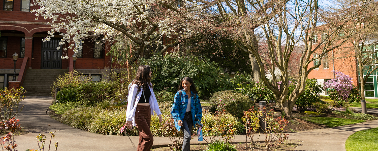 Two female students walk through Tiffany Loop with Peterson Hall in the background