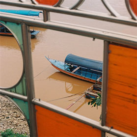 Keelan Long – Looking through the stained glass at a boat in the Golden Triangle ( the intersection of Thailand, Myanmar, and Laos)