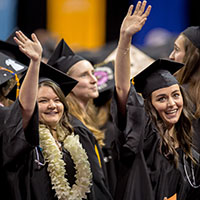 Seattle Pacific University students waving at graduation