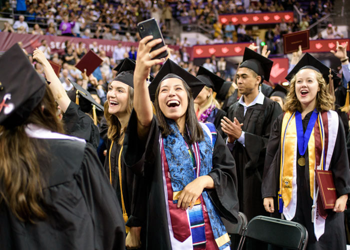 student takes a selfie at graduation