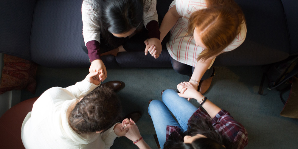 students pray in circle