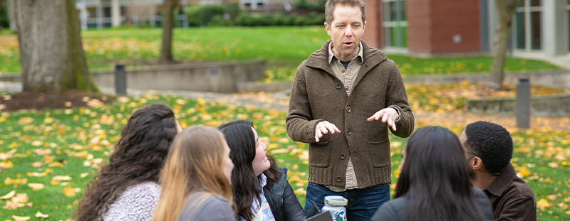 Professor Baine Craft with students outside. 