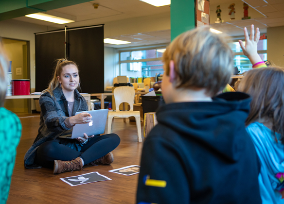 An SPU student teacher works with young children