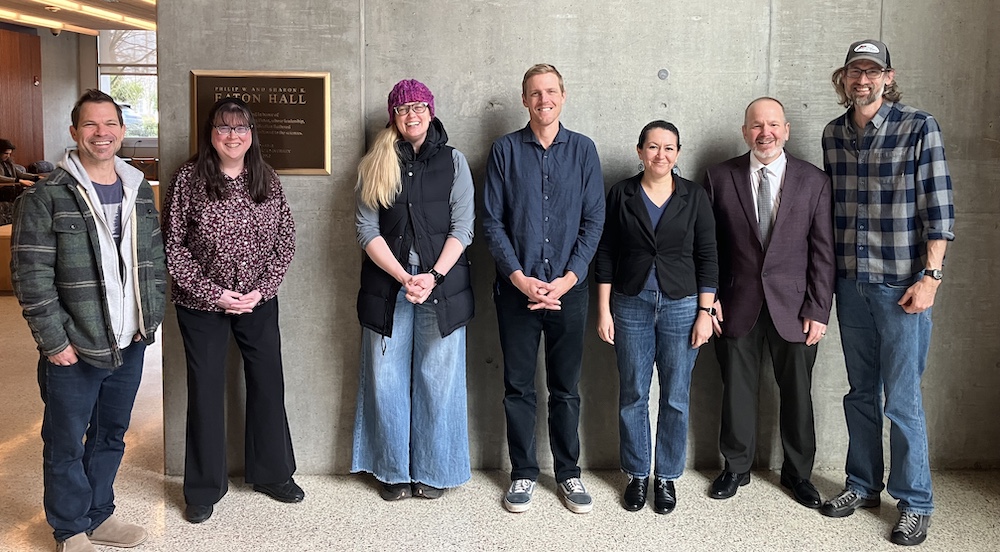 Biology Department Faculty pose in front of Eaton Hall plaque