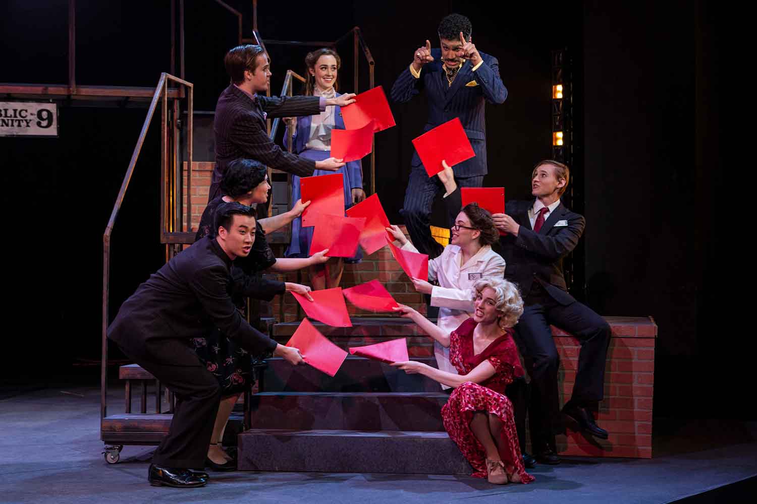 actors holding red papers