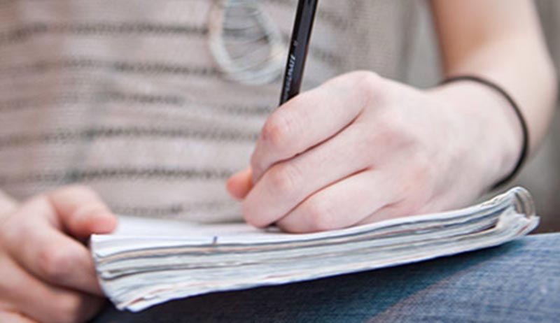 Journalism student writing in journal