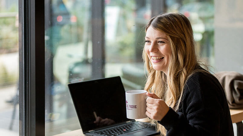 An SPU grad student works on her laptop | photo by Dan Sheehan