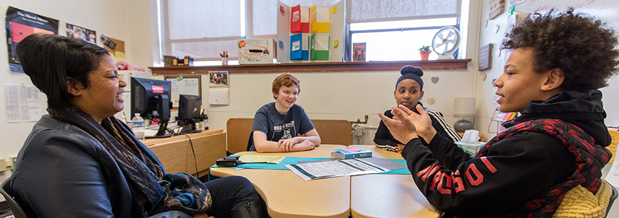 An instructor works with a diverse group of young students | photo by Dan Sheehan