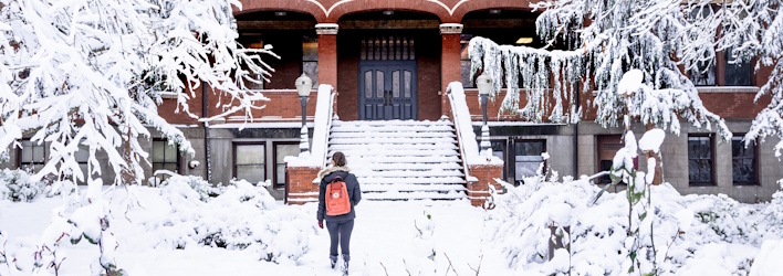 A student walks up to a snowy Peterson hall