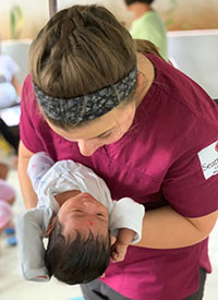 An SPU nursing student holds a baby