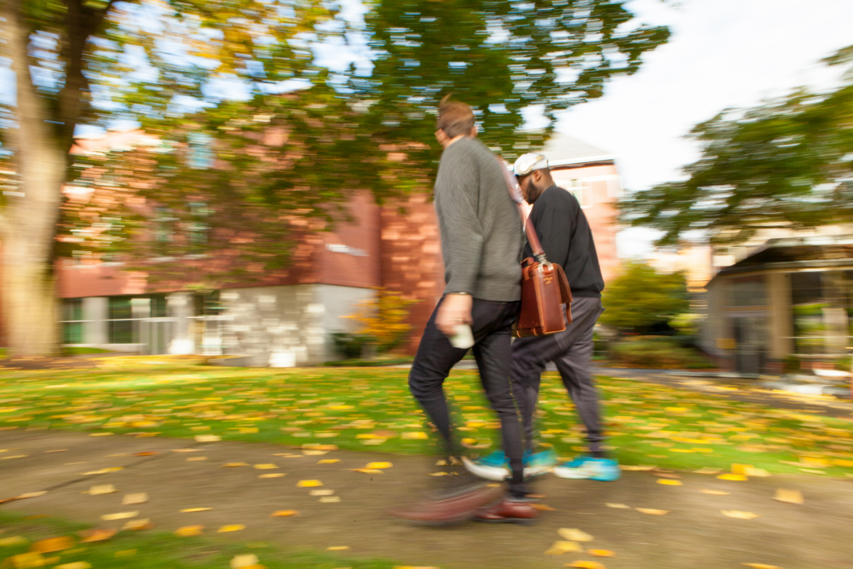 A purposely slightly blurred image of two SPU male students walking across campus near the Student Union Building