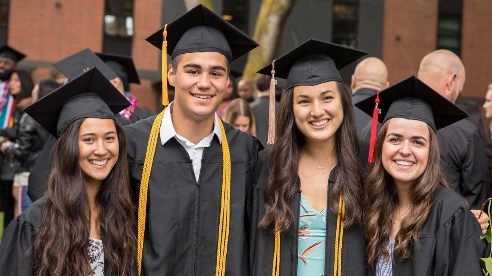 Four students in caps & gowns