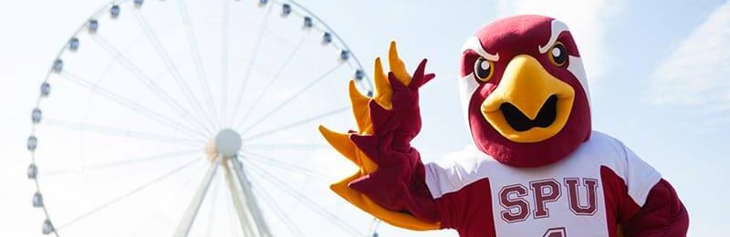 Talon mascot waving next to the Seattle great wheel