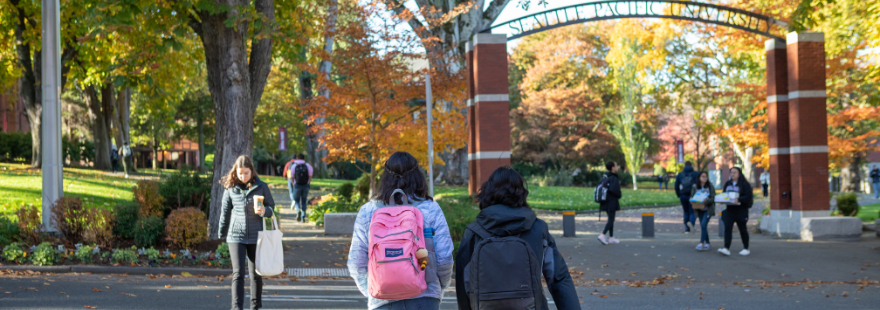 Students walking on campus near the SPU arch