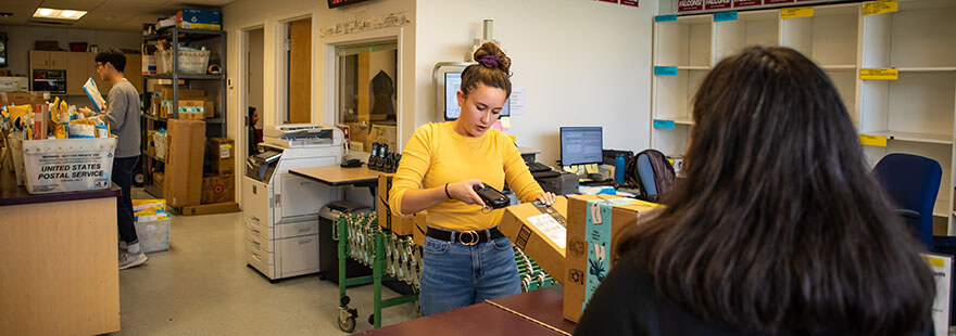 An SPU student worker scans a package
