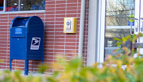 A blue United States postal Service mailbox outside the Student Union Building