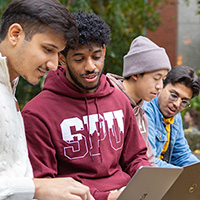 SPU students work on their laptops in Martin Square on campus