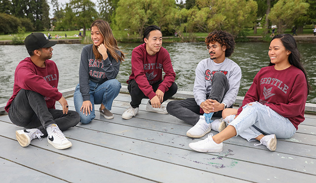 Students in SPU gear hang out on a dock at Green Lake
