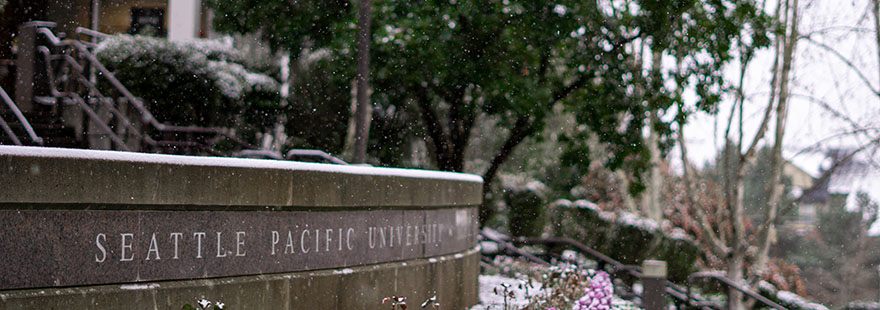 Snow falls on the Seattle Pacific University sign in Martin Square
