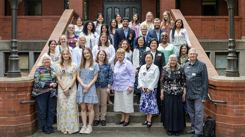 The Falconettes gather on the steps of Peterson Hall in May 2026 at their Spring Tea