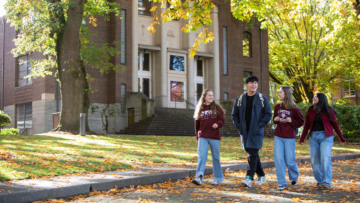 Four SPU students walk through Tiffany Loop during an autumn day