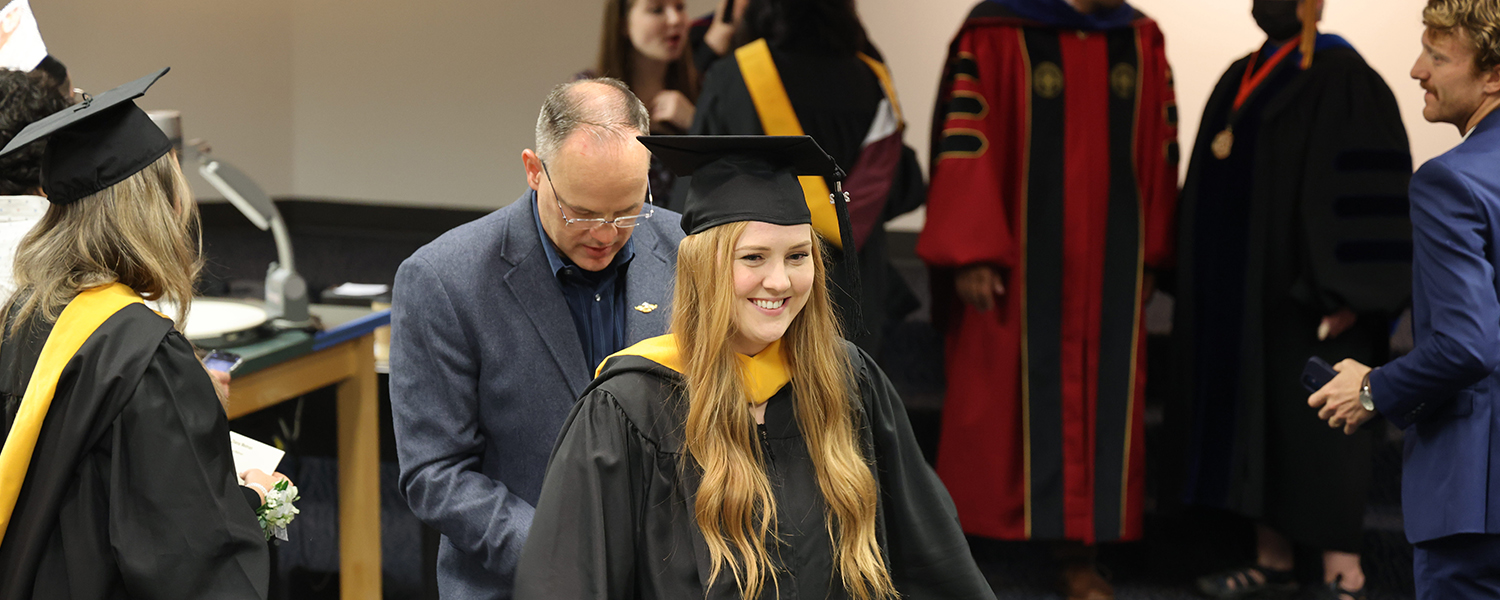 A graduate student participates in the Hooding Ceremony