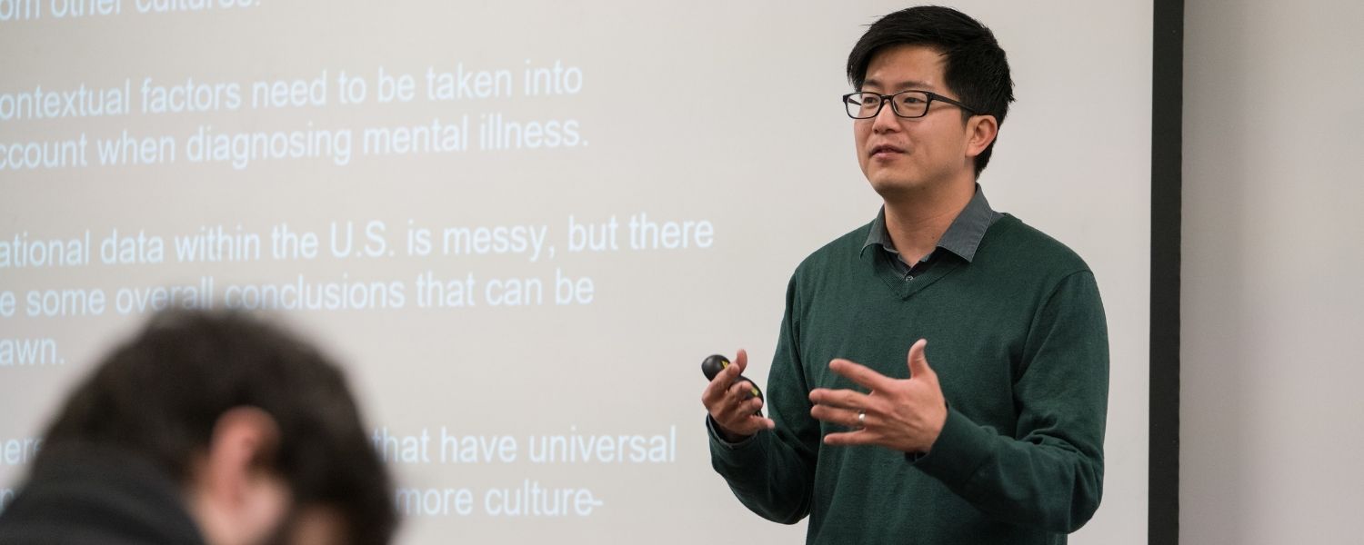 Professor of Psychology Paul Kim teaches in front of a classroom, facing his students and with his back to a whiteboard.