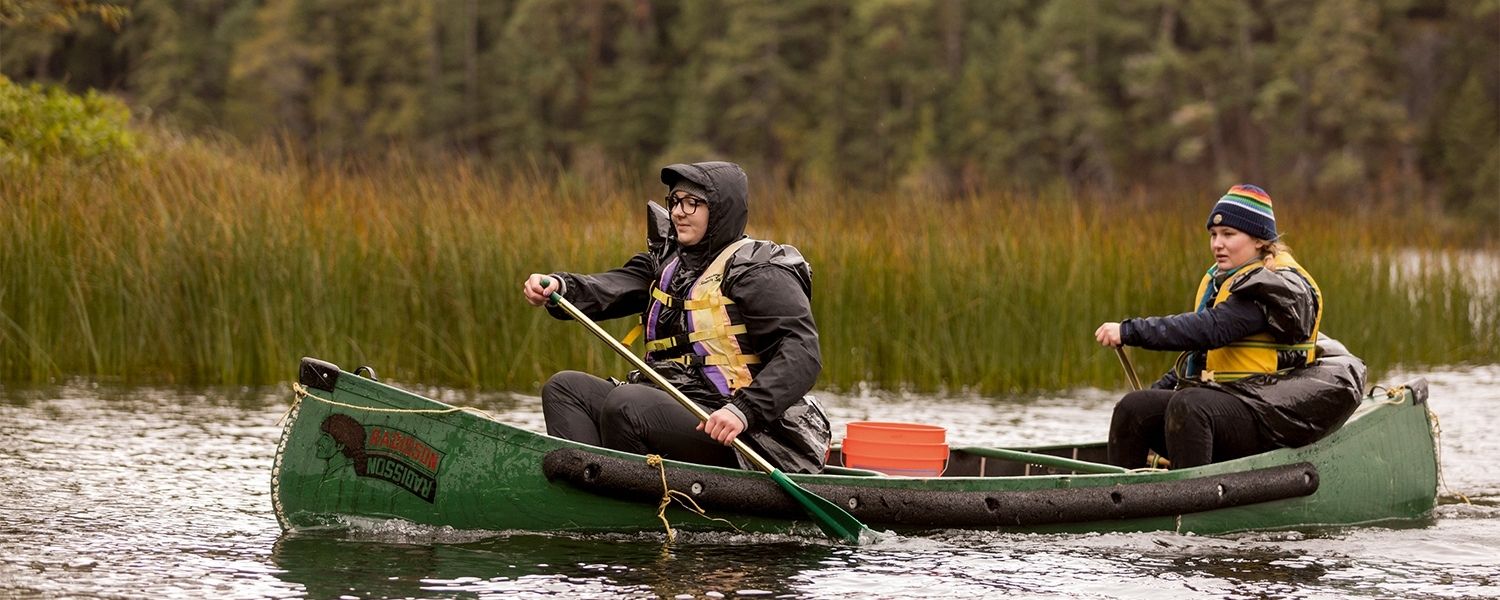 Two SPU students paddle a canoe at the Blakely Island Field Station