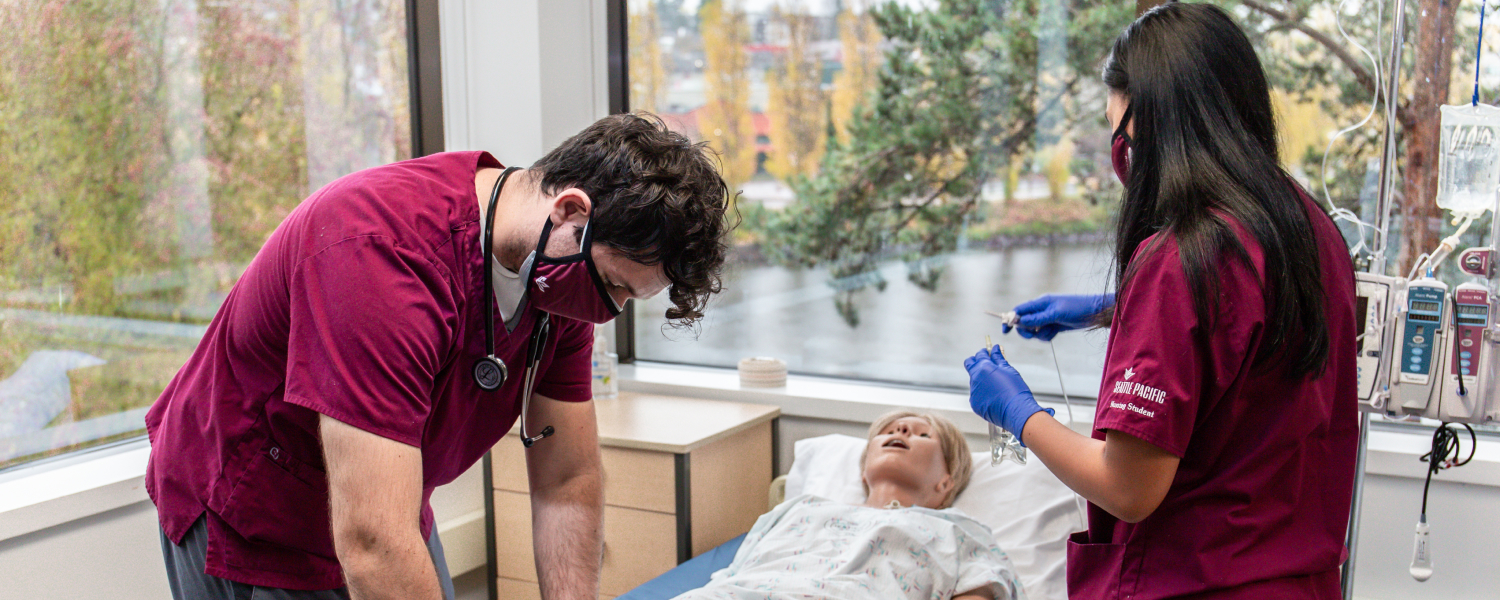 Two undergraduate nursing students at SPU work in the lab.