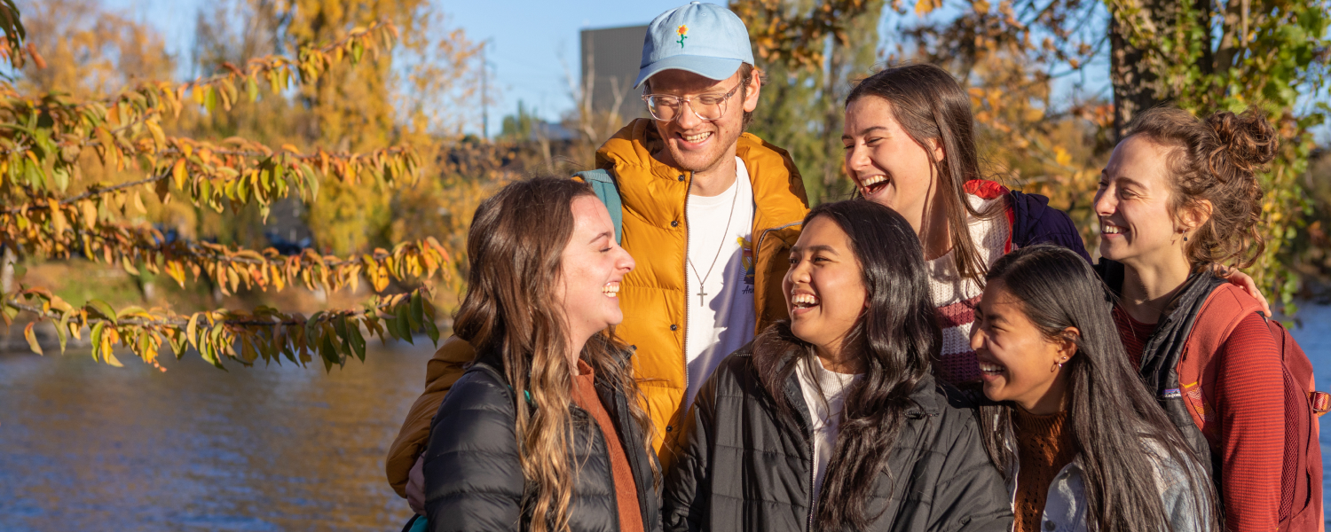 Six SPU students talk and laugh near the canal near campus.