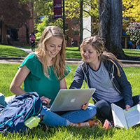 Two SPU students do homework in Tiffany Loop on a sunny day