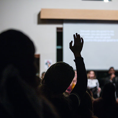 A congregant raises her hand during worship
