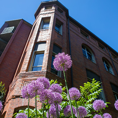 SPU's Alexander and Adelaide Hall from a unique perspective, with flowers in front of it