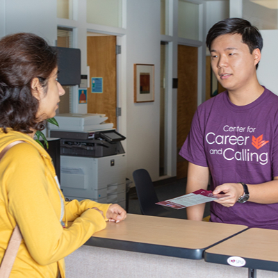 A male Center for Career and Calling worker assists a female student with career-readiness questions