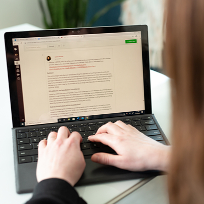 A graduate student works remotely on her degree via her laptop.