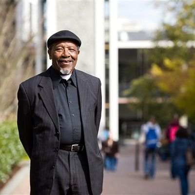 Renowned reconciliation leader, Dr. John Perkins, standing on the SPU campus