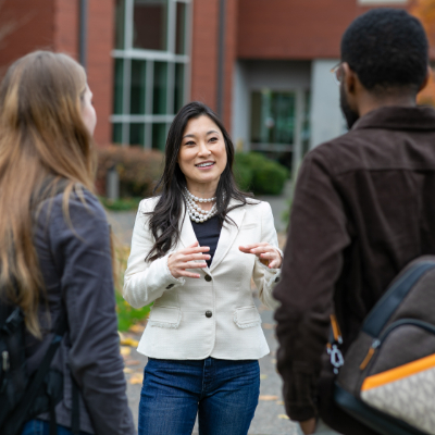  Dr. Jenny​ Lee Vaydich​ speaks with two graduate students in Tiffany Loop