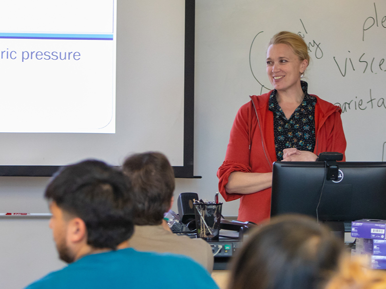 While wearing a red front-zip sweater, Cara Wall-Scheffler, professor of biology, teaches one of her biology classes at Seattle Pacific University.