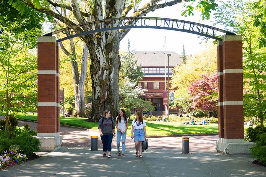 Students walking under SPU arch