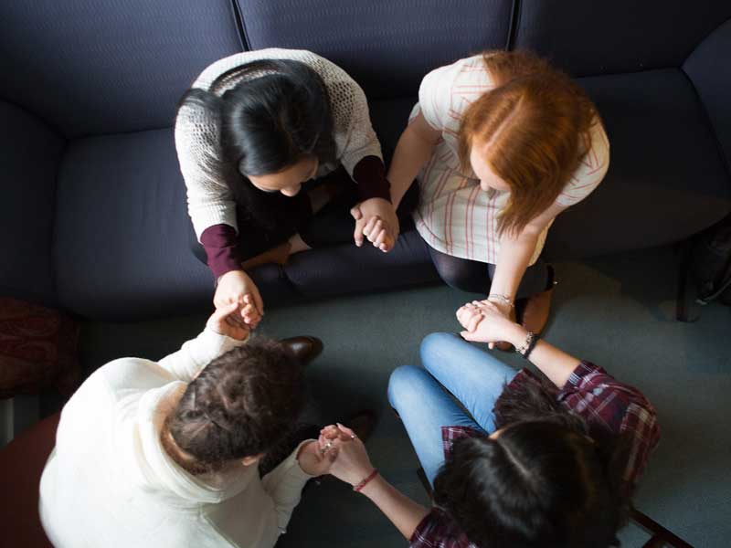 Students in a circle praying