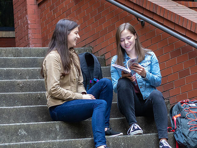 Two SPU students study on the steps of Peterson Hall