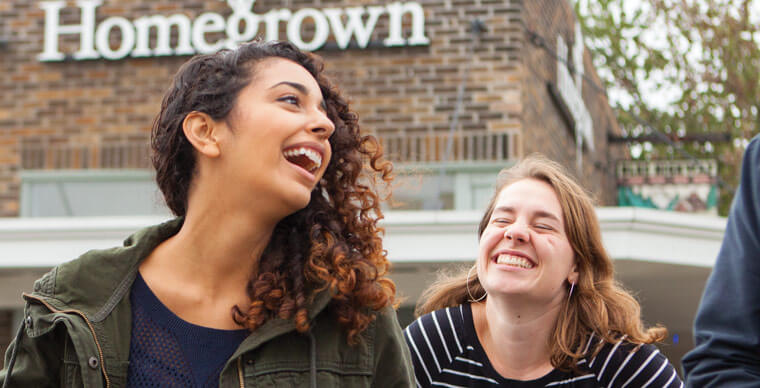 Students laugh together in front of Homegrown on Queen Anne