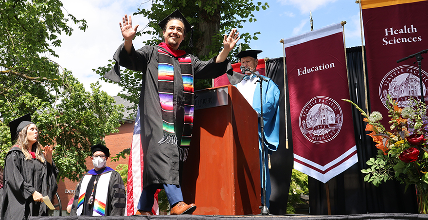A happy male student crosses the stage at Seattle Pacific University