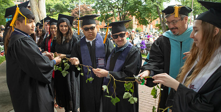 Jeff Jordon, Vice President for Student Life, cuts the ivy strand held by a row of students, signifying the students graduation and release into the world - photo by Esther Yun