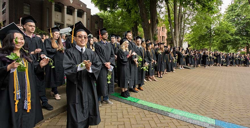 SPU undergraduate students smile and celebrate as they line up around Tiffany Loop for the annual Ivy Cutting Ceremony.