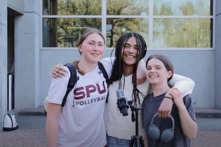 Students smile together in front of the dining hall