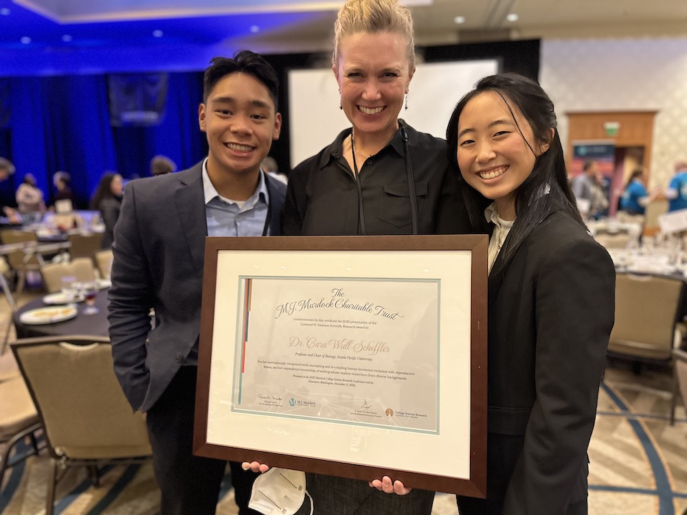 Dr. Wall-Scheffler holding her award, along with students Richo Abenojar and Yu-Jin Youn.